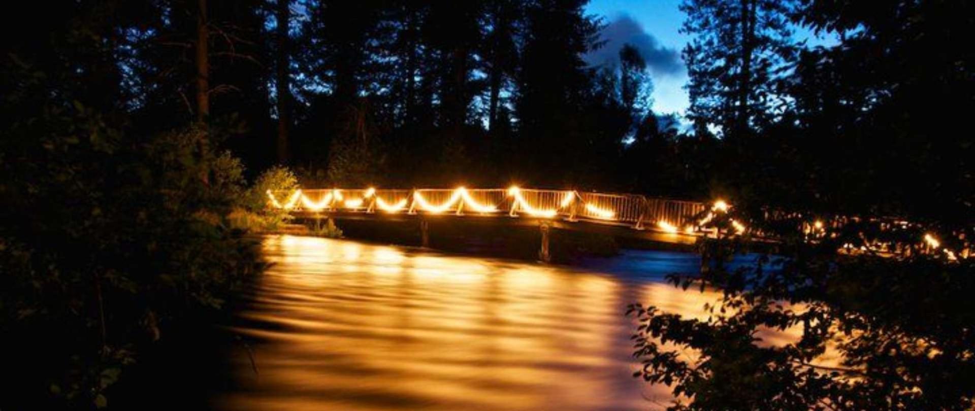 The foot bridge at Cold Springs Resort is beautifully illuminated at night, guiding guests back to their cabins and RVs