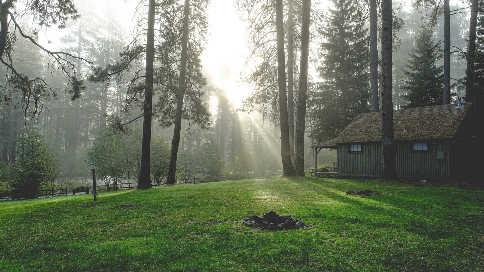 The Historic Log Cabin, at Cold Springs Resort & RV Park, sits blanketed in fog on the banks of the Metolius River in Camp Sherman, Oregon