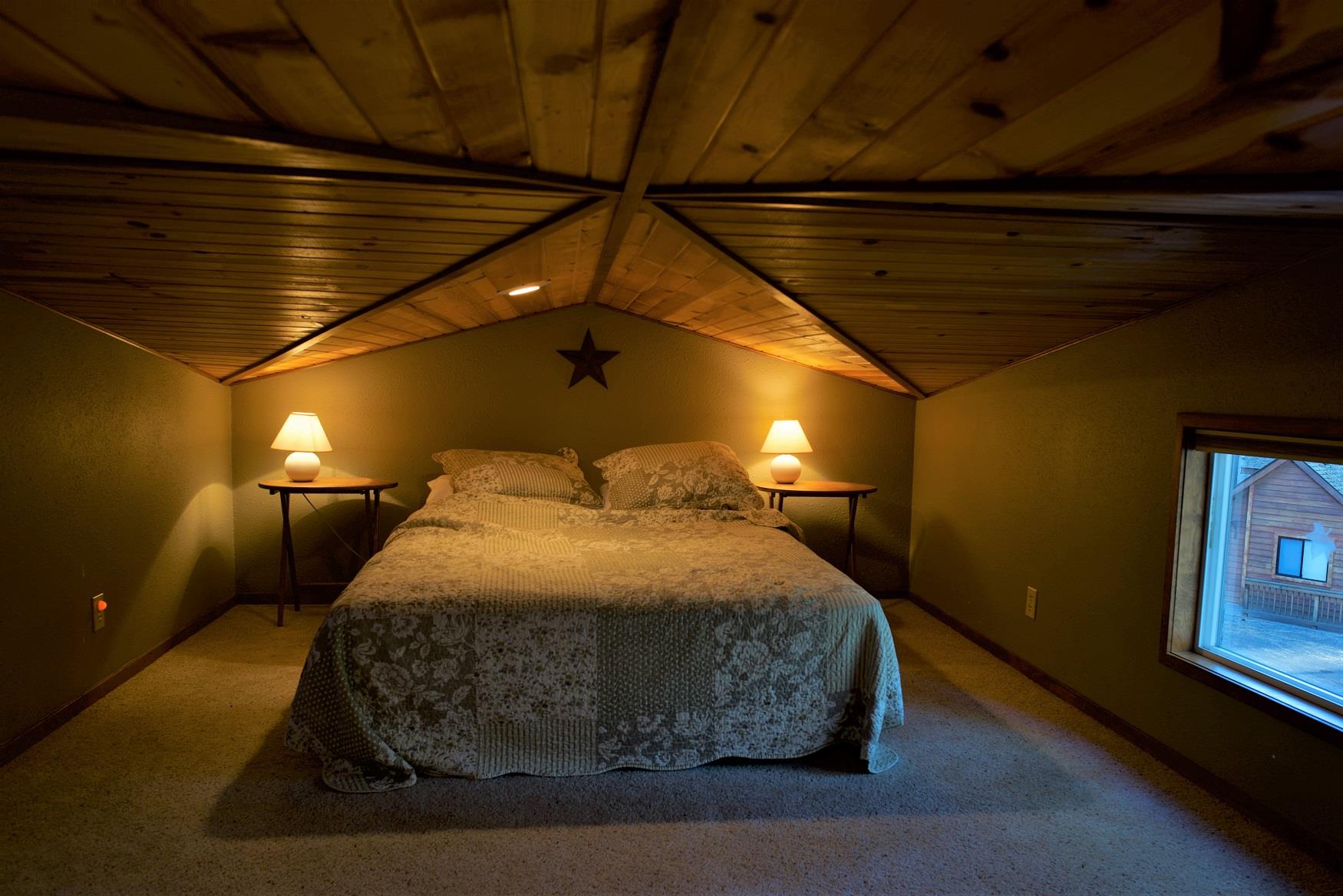 Get your best night sleep in the cozy queen bed in the loft of Alder Cabin at Cold Springs Resort & RV Park in Camp Sherman, Oregon