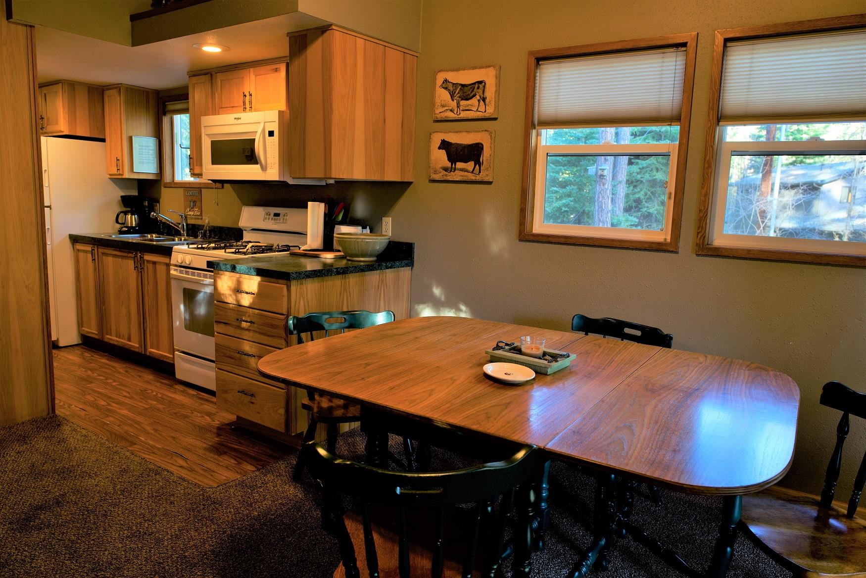 Serve up a delicious family dinner in the spacious dining and kitchen area of Alder Cabin at Cold Springs Resort & RV Park in Camp Sherman, Oregon