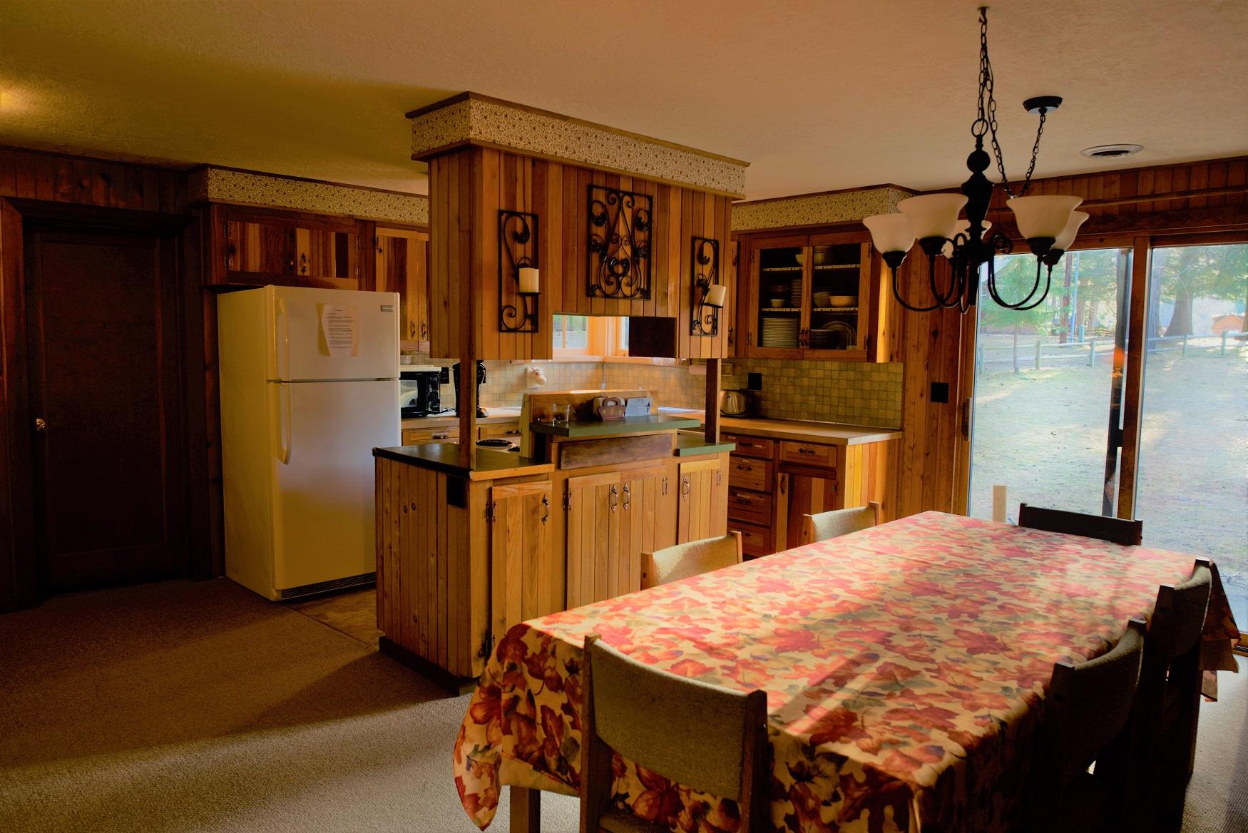 Serve up a delicious family dinner in the spacious dining and kitchen area of Haberman Cabin at Cold Springs Resort & RV Park in Camp Sherman, Oregon