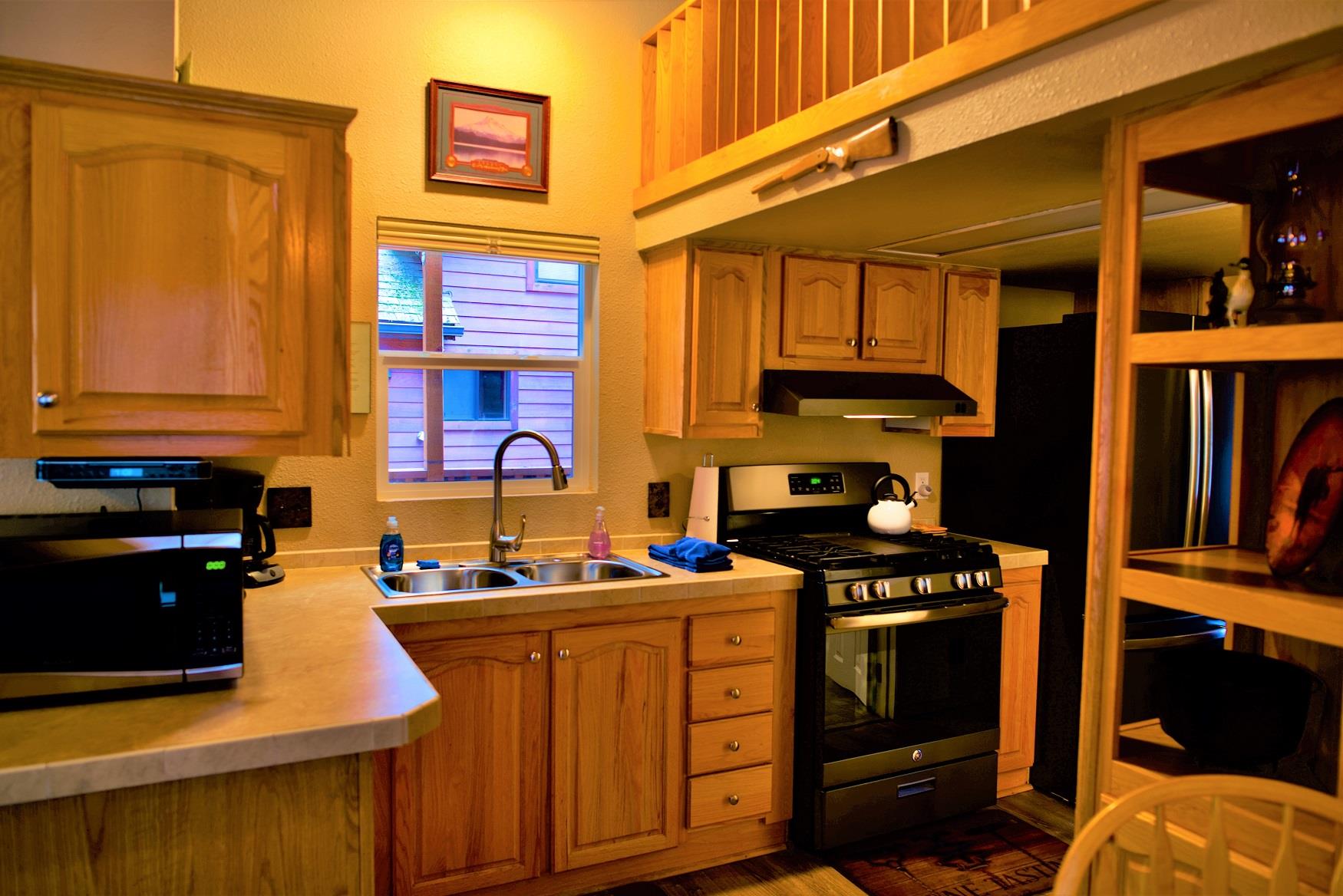Cook up a delicious family dinner in the kitchen of Juniper Cabin at Cold Springs Resort & RV Park in Camp Sherman, Oregon