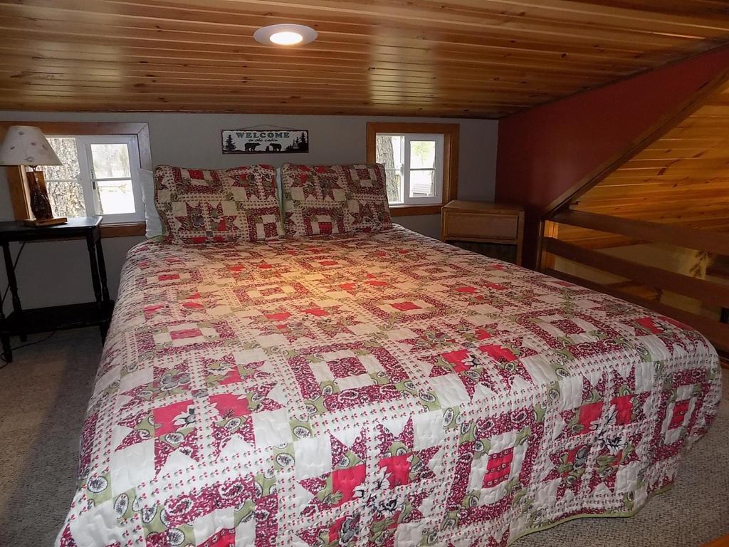 Get your best night sleep in the cozy queen bed in the loft of Pinecone Cabin at Cold Springs Resort & RV Park in Camp Sherman, Oregon